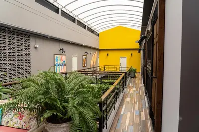a hallway with plants and a yellow wall at Hotel El Meson in La Dorada