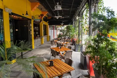 an outdoor patio with tables and chairs and plants at Hotel El Meson in La Dorada