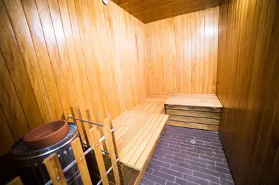 a wooden sauna with a bench and a trash can at Hotel Golden Palermo in Medellín