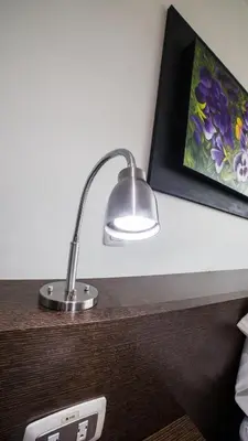 a lamp sitting on top of a wooden desk at Hotel Golden Palermo in Medellín