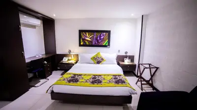 a bedroom with a bed and a painting on the wall at Hotel Golden Palermo in Medellín