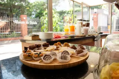 a tray of cupcakes on a wooden plate on a table at Alcazar de Oviedo by EE Hoteles in Medellín