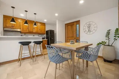 a kitchen with a wooden table and chairs at Alcazar de Oviedo by EE Hoteles in Medellín