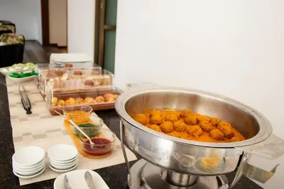 a counter with a pot of food in a kitchen at Alcazar de Oviedo by EE Hoteles in Medellín