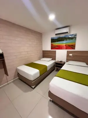 a bedroom with two beds and a painting on the wall at Hotel Sie7e in Medellín