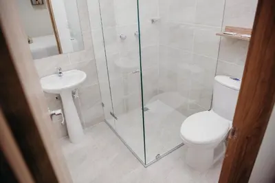 a bathroom with a shower and a toilet and a sink at Hotel Sie7e in Medellín