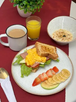 a plate of breakfast food on a table with a cup of coffee at Hotel Sie7e in Medellín