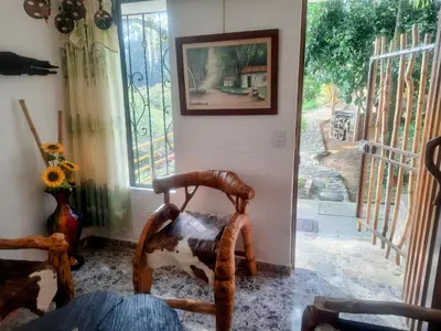 a room with a rocking chair and a window at Apartamento Campestre Medellin in Medellín