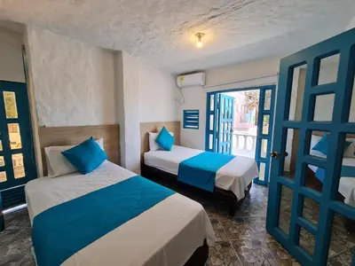 two beds in a room with blue and white at CABAÑA 1 LA ALDEA in Doradal