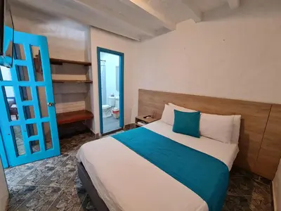 a bedroom with a large bed and a blue door at CABAÑA 1 LA ALDEA in Doradal