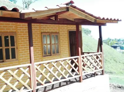 a small brick house with a wooden deck at Alojamiento Campestre Cabañas Mirador Ingrumá Riosucio Caldas in Ruiosucio