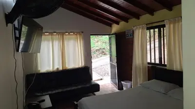 a bedroom with a bed and a sliding glass door at Alojamiento Campestre Cabañas Mirador Ingrumá Riosucio Caldas in Ruiosucio