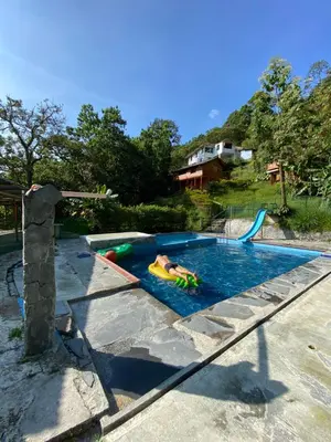 a person swimming in a swimming pool with a pool at Eco Lodge La Juanita in Manizales
