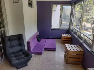 a living room with a purple couch and a chair at Rock Hostel Medellin in Medellín