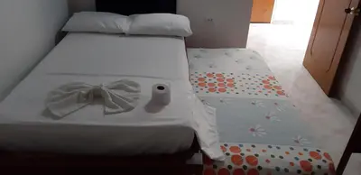 a bedroom with a bed with a bow on it at HOTEL LA QUINTA in La Dorada