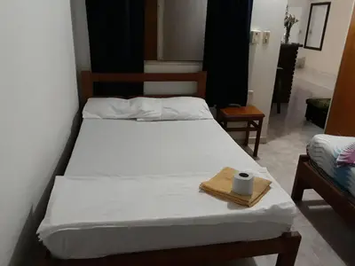 a bed with a towel and a napkin on it at HOTEL LA QUINTA in La Dorada