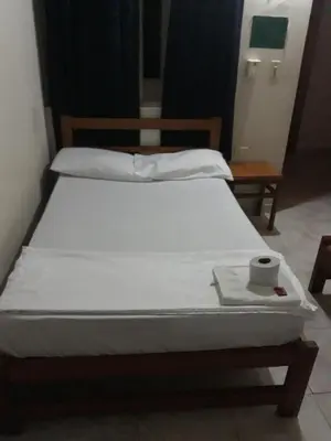 a bedroom with two beds and a table with a towel at HOTEL LA QUINTA in La Dorada