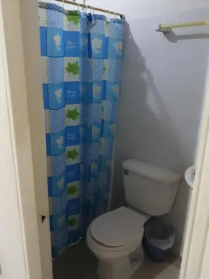 a bathroom with a toilet and a shower curtain at HOTEL LA QUINTA in La Dorada