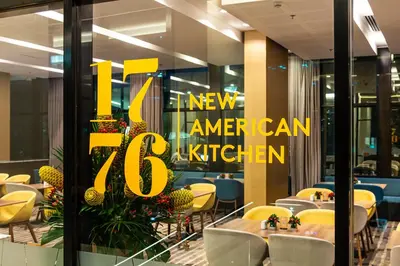 a restaurant with a sign that says new american kitchen at Hotel Estelar Square in Medellín