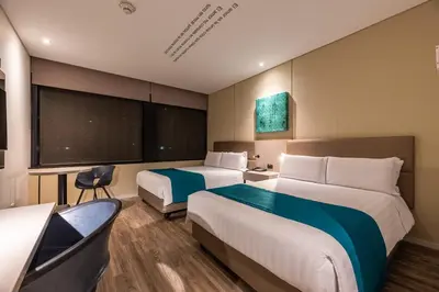 a hotel room with two beds and a tv at Hotel Estelar Square in Medellín