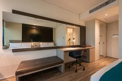 a bedroom with a desk and a bed with a mirror at Hotel Estelar Square in Medellín