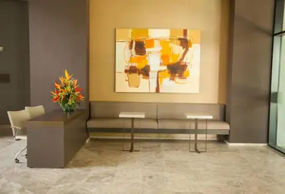 a waiting room with a couch and a painting on the wall at Hotel Estelar Square in Medellín