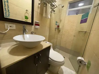 a bathroom with a sink and a toilet and a shower at Hotel Bolivariana Plaza Medellin in Medellín