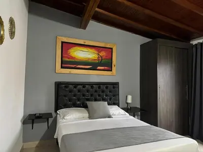 a bedroom with a bed and a painting on the wall at Gemas San Joaquin 1 in Medellín