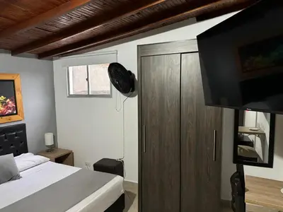 a bedroom with a bed and a wooden cabinet at Gemas San Joaquin 1 in Medellín