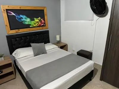 a bedroom with a bed with a painting on the wall at Gemas San Joaquin 1 in Medellín