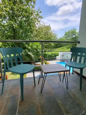 a patio with two chairs and a bench on a balcony at Hotel Puerto Triunfo in Doradal