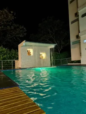 a swimming pool at night with a water fountain at Hotel Puerto Triunfo in Doradal