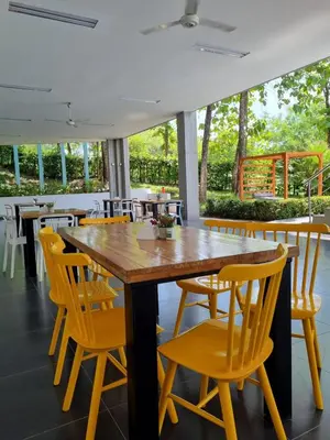 a dining room with a wooden table and yellow chairs at Hotel Puerto Triunfo in Doradal