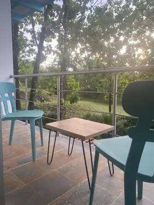 a porch with two chairs and a table and a chair at Hotel Puerto Triunfo in Doradal