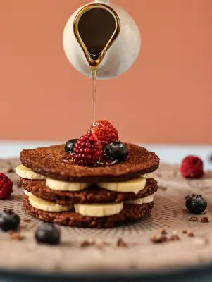 a stack of pancakes with fruit and syrup on top at Celestino Boutique Hotel & Spa in Medellín