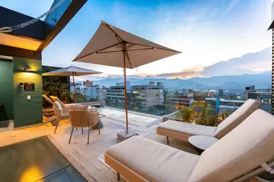 a patio with chairs and an umbrella and a table at Celestino Boutique Hotel & Spa in Medellín