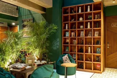 a room with green walls and a wooden book shelf at Celestino Boutique Hotel & Spa in Medellín