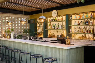 a bar with stools and a counter with alcohol bottles at Celestino Boutique Hotel & Spa in Medellín
