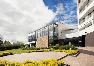 an office building with a garden in front of it at Hotel Lagoon in Rionegro