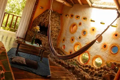 a room with a rock wall with a hammock in it at Hospedaje Solentiname in Medellín