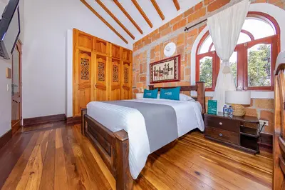 a bedroom with a bed and a brick wall at Ayenda Llanogrande Inn in Rionegro