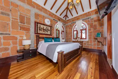 a bedroom with a bed and a brick wall at Ayenda Llanogrande Inn in Rionegro