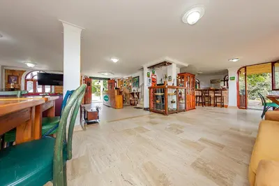 a large living room with wooden floors and bookshelves at Ayenda Llanogrande Inn in Rionegro