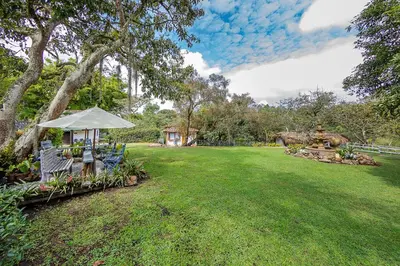 a lawn with a gazebo and chairs in a yard at Ayenda Llanogrande Inn in Rionegro