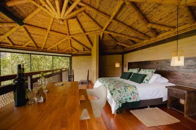 a bedroom with a bed and a wooden table at Cannúa Lodge Hotel in Marinilla