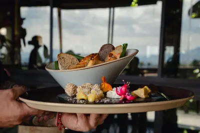 a person holding a plate with a bowl of food at Cannúa Lodge Hotel in Marinilla