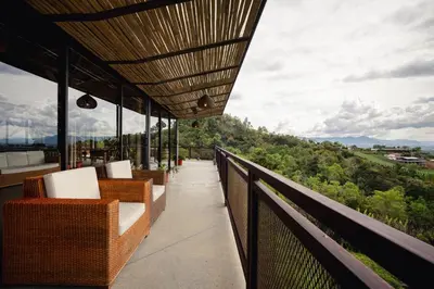 a balcony with chairs and a view of the mountains at Cannúa Lodge Hotel in Marinilla