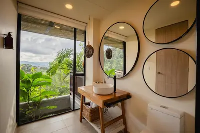 a bathroom with a sink and two mirrors at Cannúa Lodge Hotel in Marinilla