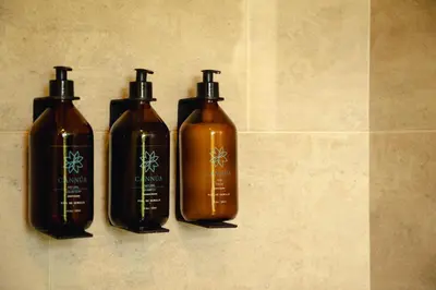 a group of three shampoo bottles sitting on a wall at Cannúa Lodge Hotel in Marinilla