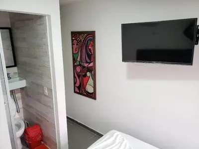 a bathroom with a flat screen tv on a wall at Hotel zona express sandiego in Medellín